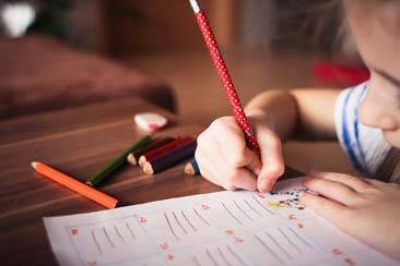 Student filling workbook with pencil as we answer your questions on Adventist Education - AAAF