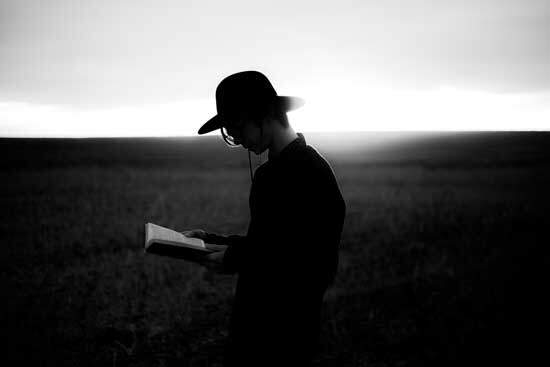 A man walking and reading the Bible