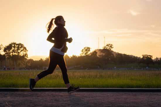 Woman jogging outdoors as we learn the importance and benefits of walking and jogging as good and practical exercise.