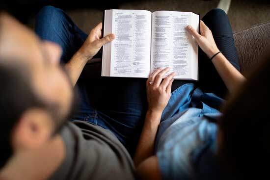 Husband & Wife reading Bible together as God heals & restores their love, drawing them into a close relationship with Himself