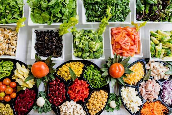 A salad bar with colorful vegetables and greens, food that Adventists eat to be faithful stewards of their bodies