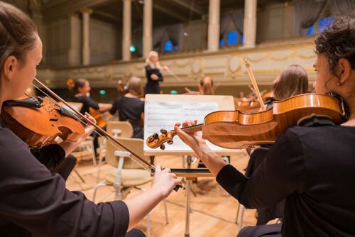 Adventist educators teaching violin lessons to students as part of the development of their individuality and God-given faculties