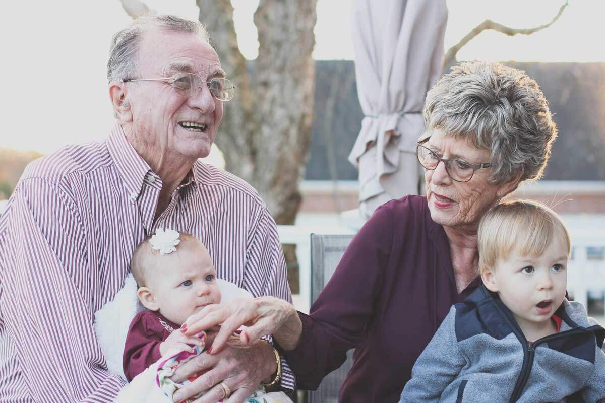 Elderly couple holding young children as we explore why Adventists are known for their high regard for healthful living