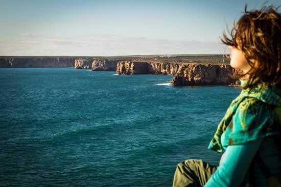 A woman sitting on a cliff near the sea and enjoying the Sabbath
