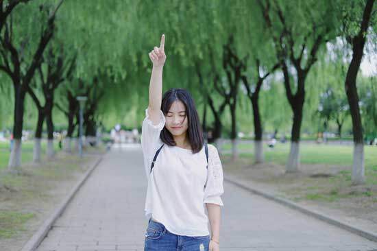 A girl pointing upward as she reflects on the first four commandments and the way they guide our relationship with God