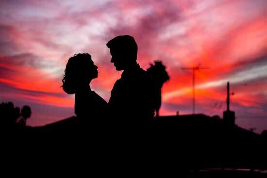A silhouette of a couple holding each other in the sunset, the way Adam and Eve might have enjoyed each other in the Garden of Eden