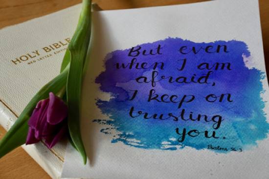 A Bible next to a flower and a positive message about trusting God in fearful times