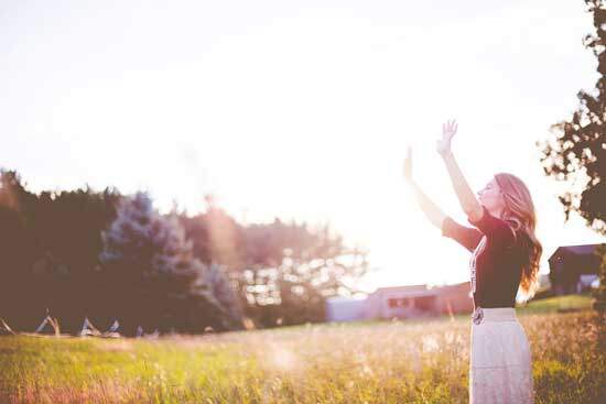 A woman raising her hands to God and praising Him