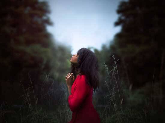Woman in red praying for God's guidance, as we learn that we are dwelling places for the Holy Spirit.