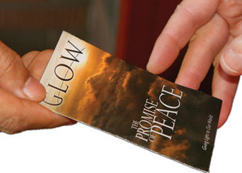 Person handing another a track on the Promise of Peace, how to become an Adventist through faith in Jesus alone.