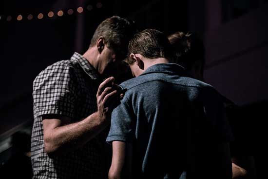 Young men praying together as we learn prayer is talking to God as to a close friend and opening of our hearts to Him