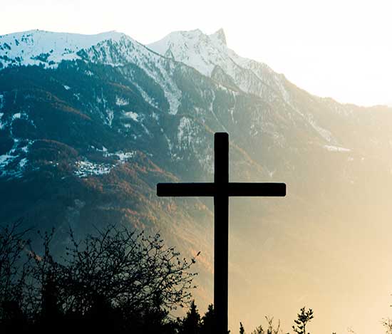 Cross near a mountain as we study how Jesus bore the wages of our sins on the Cross of Calvary and offers us Eternal life.