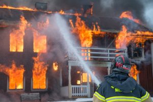 Firefighter A firefighter spraying water on a burning house, a loss of a possession
