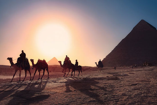 Travelers on camels before pyramids of Egypt as we discuss mosaic or ceremonial laws given to Israelite in the wilderness.