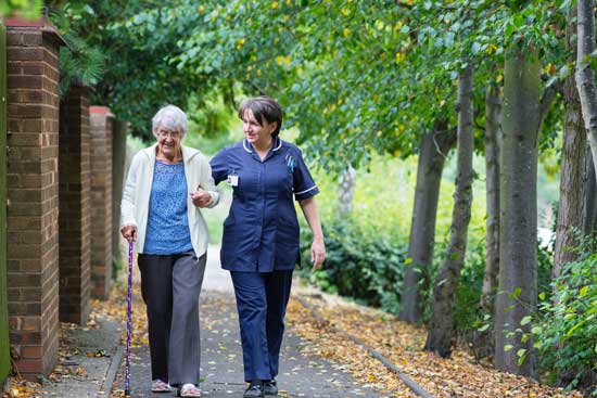 Elderly woman walking with nurse as Adventist Health Studies examine the relationship between lifestyle, diet & diseases