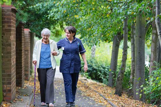 Elderly woman walking with nurse as Adventist Health Studies examine the relationship between lifestyle, diet & diseases