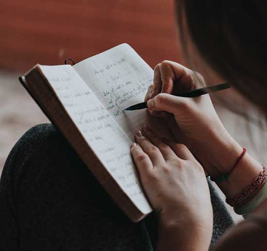 Woman journaling her thoughts, feelings, prayers, and Scripture passages as self-inventory helps in self-control journey.
