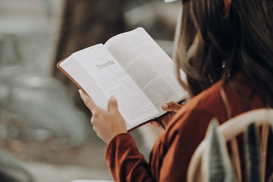 Reading book of Proverbs Woman reading the book of Proverbs as we learn about the wise saying of King Solomon, meant to guide God's people.