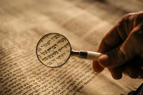 Hebrew scrolls through magnifying glass as we learn who wrote the Old Testament and when it was written.