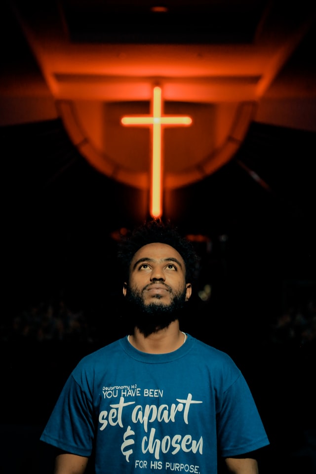 A man with a cross behind him to symbolize the power of God to heal us spiritually