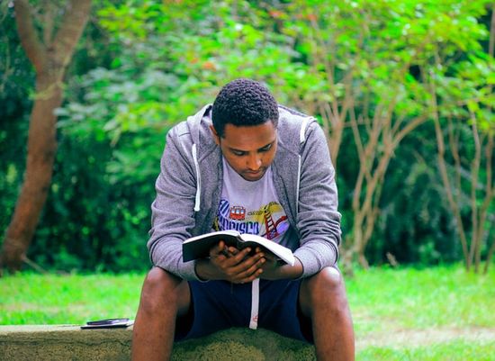 A man reads his Bible outdoors to get the spiritual benefits of fresh air