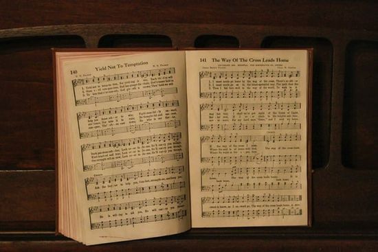 Hymnal open to different songs Yield Not to Temptation and the Way of the Cross Leads Home