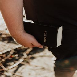 Person carrying Holy Bible to Sabbath School