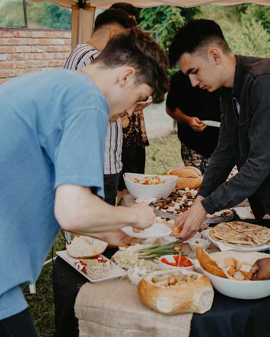 A man putting food on his plate at a potluck