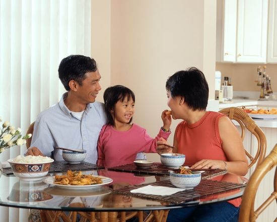 Family of three enjoying a Sabbath meal together resting.