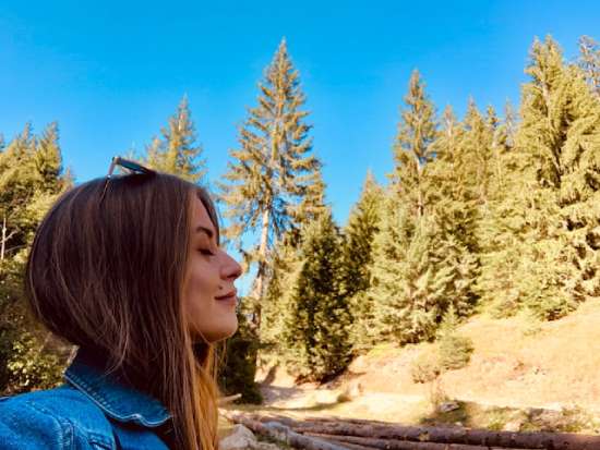 A woman breathes in fresh forest air