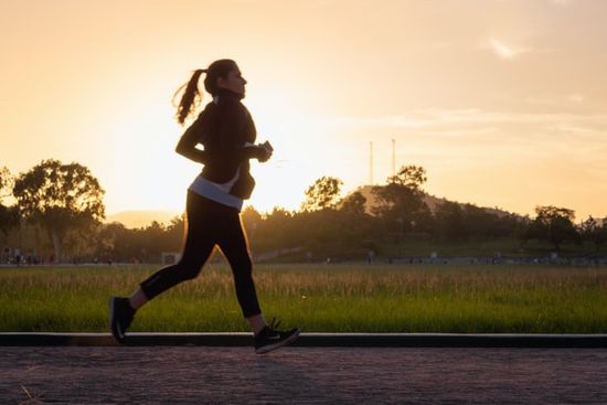 A woman jogging at sunrise to get her exercise