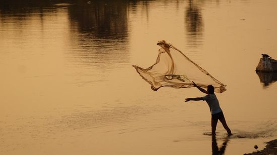 A man casting a fishing net, similar to the one Jesus spoke of to illustrate the kingdom of heaven
