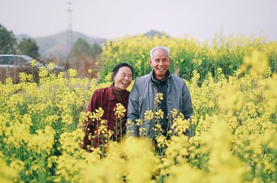 A healthy Adventist couple enjoying a field of yellow flowers