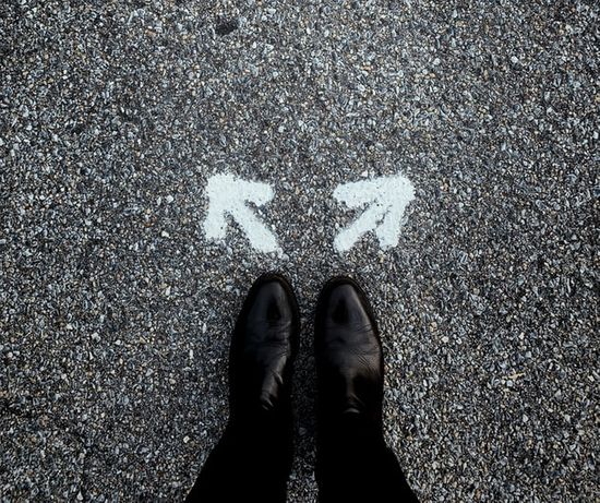 Feet standing behind two arrows pointing in different directions