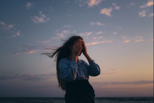 A person sitting on a bench at seashore looking at sunset at the horizon, as we discover blessings of Sabbath for ourselves.