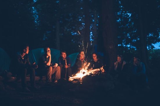 People sitting around a a campfire telling stories, just as Jesus told parables to teach lessons