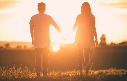 A couple holding hands in the sunset and enjoying the gift of life from God