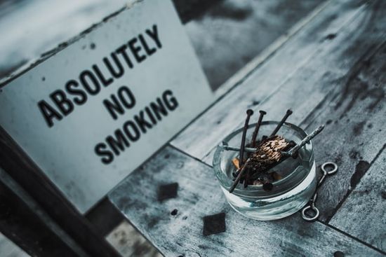 A sign saying absolutely no smoking and an ashtray encouraging people to have temperance.