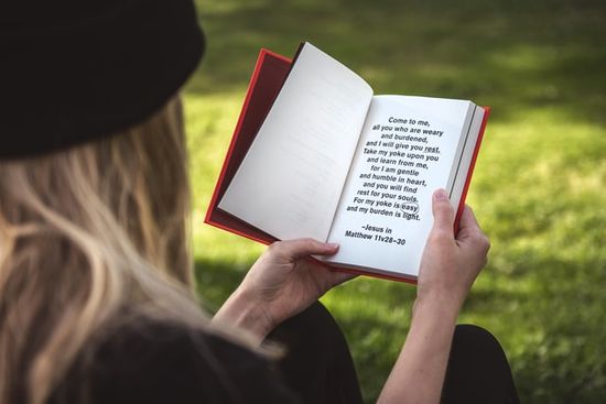 A woman reading a Bible text to grow her trust in divine power