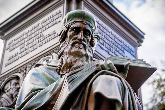 A sculpture of John Wycliffe reading the Bible