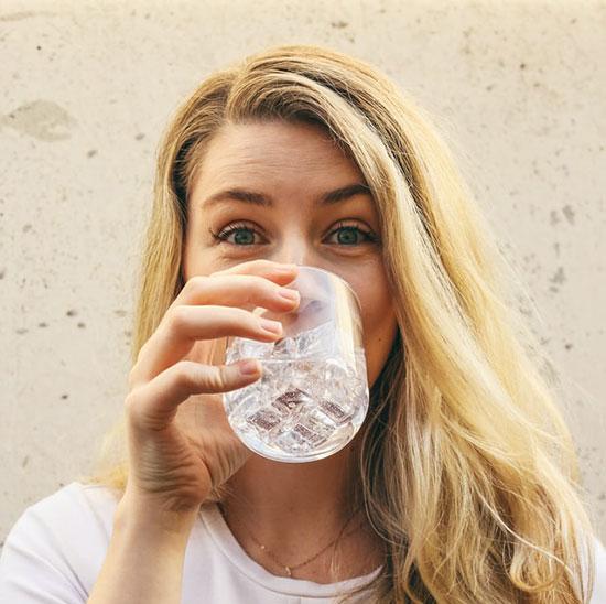 A woman drinking from a bottle of water