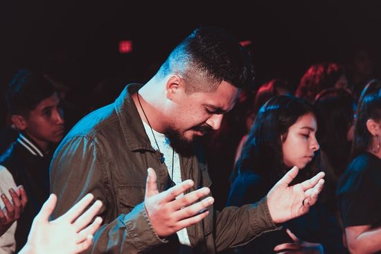 People praying and lifting their hands to God at an evangelistic campaign