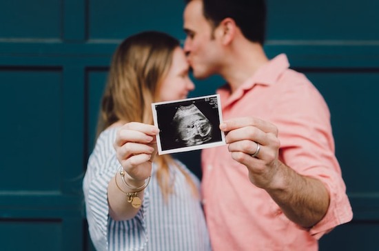 An Adventist couple holding an ultrasound picture in excitement for the new human life