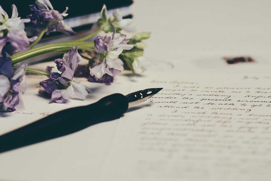 A ink pen resting on top of a letter