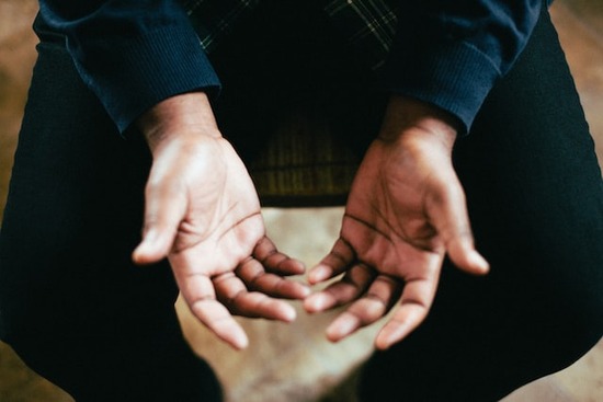 Man's open hands in prayer as we learn asking for our daily physical and spiritual needs in prayer as taught in Lord's prayer