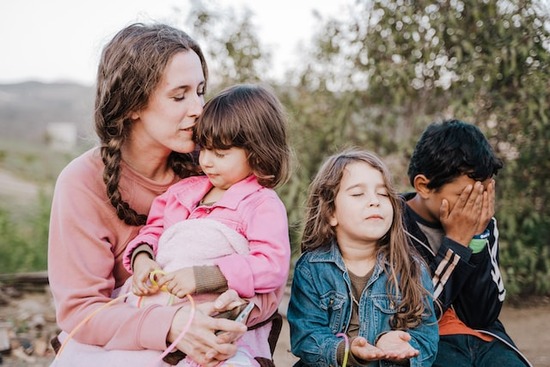 A Christian woman prays with her three children