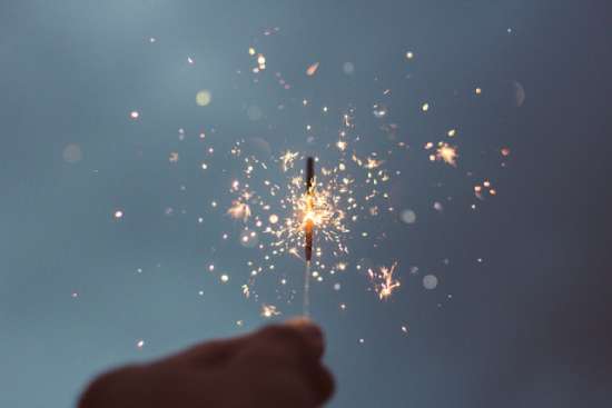 A hand holding a sparkler to celebrate a holiday