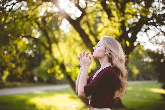 A woman praying to Jesus and accepting Him as her Savior