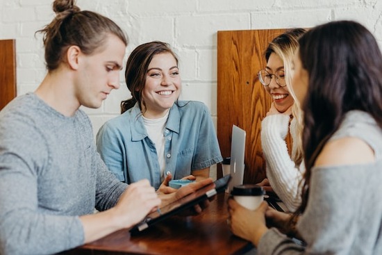 A group of Adventist young adults sitting around a table and having a Bible study