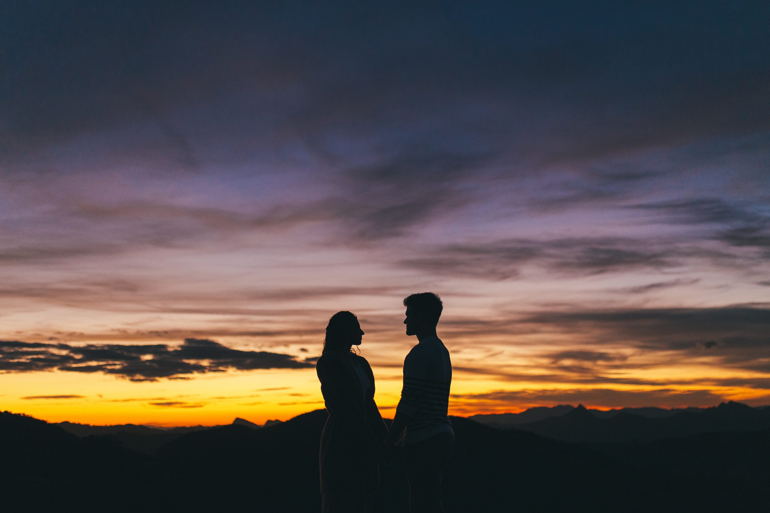 A couple holding hands in the sunset, reminding us that God made man and woman to reflect the glory of God